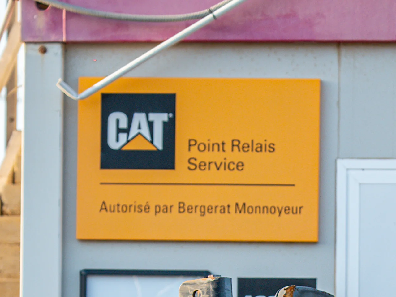 Le panneau « CAT Point Relais Service – Autorisé par Bergerat Monnoyeur » sur l'agence Locamat.